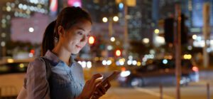 Woman use of mobile phone in city at night