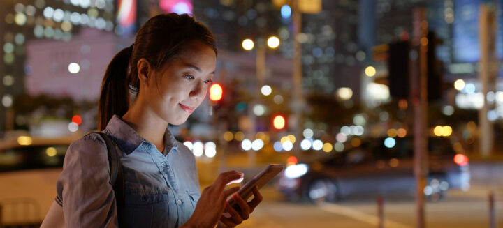Woman use of mobile phone in city at night